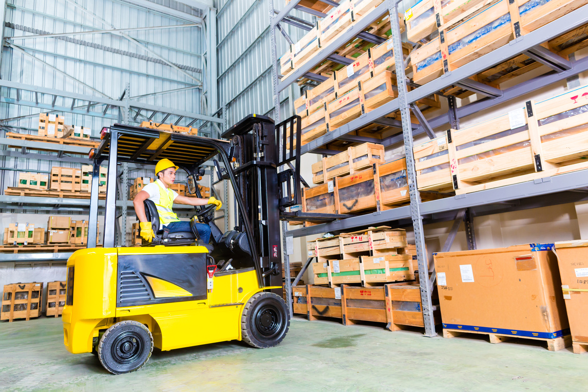 Operator driving a forklift in a warehouse